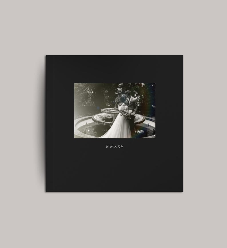 May include: A black square wedding album with a vintage photograph of a couple embracing near a fountain. The photograph is in black and white. The Roman numeral "MMXXV" is printed at the bottom of the album.
