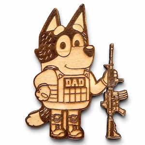 Könnte beinhalten: Holzausschnitt eines Cartoon-Hundes, der eine Weste mit dem Wort "DAD" trägt und ein Gewehr hält. Der Hund ist hellbraun mit dunkelbraunen Akzenten. Das Gewehr ist ebenfalls aus Holz.