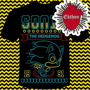 May include: Black t-shirt with a neon blue and yellow graphic of Sonic the Hedgehog running. The text "Sonic The Hedgehog" is above the graphic, and the numbers "19" and "91" are below the graphic.