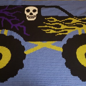 May include: A crocheted monster truck blanket in blue, black, yellow, and purple. The truck has a skull on the side and flames on the hood.