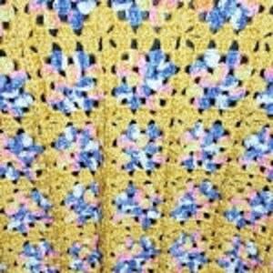 May include: A crocheted blanket with a yellow, pink, blue, and white color scheme. The blanket is made with a granny square pattern.