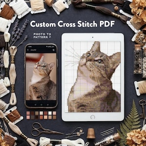 以下が含まれることがあります： 猫のカスタムクロスステッチPDFパターンを表示するスマートフォンとタブレット。刺繍糸、ハサミ、指ぬき、針に囲まれています。テキストには「Custom Cross Stitch PDF」および「PHOTO TO PATTERN」と書かれています。