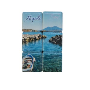 May include: A set of six square tiles arranged in a grid, featuring a continuous photographic print of a coastal scene in Naples. The image displays the word Napoli, a mountain, rocky shorelines, blue water, and a small boat floating on the sea.