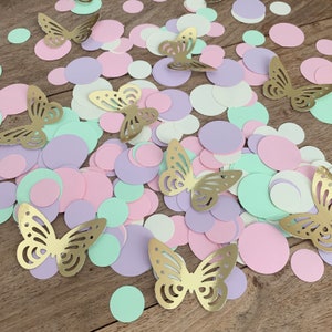 Op de afbeelding: Assortiment van pastelroze, paarse en groene papieren cirkels met gouden glittervlinderconfetti.