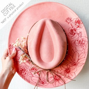 May include: A pink cowboy hat with a floral design. The hat has a wide brim and a rounded crown. The brim is decorated with red floral outlines. The hat is adorned with a small bouquet of dried flowers and a brown leather band.
