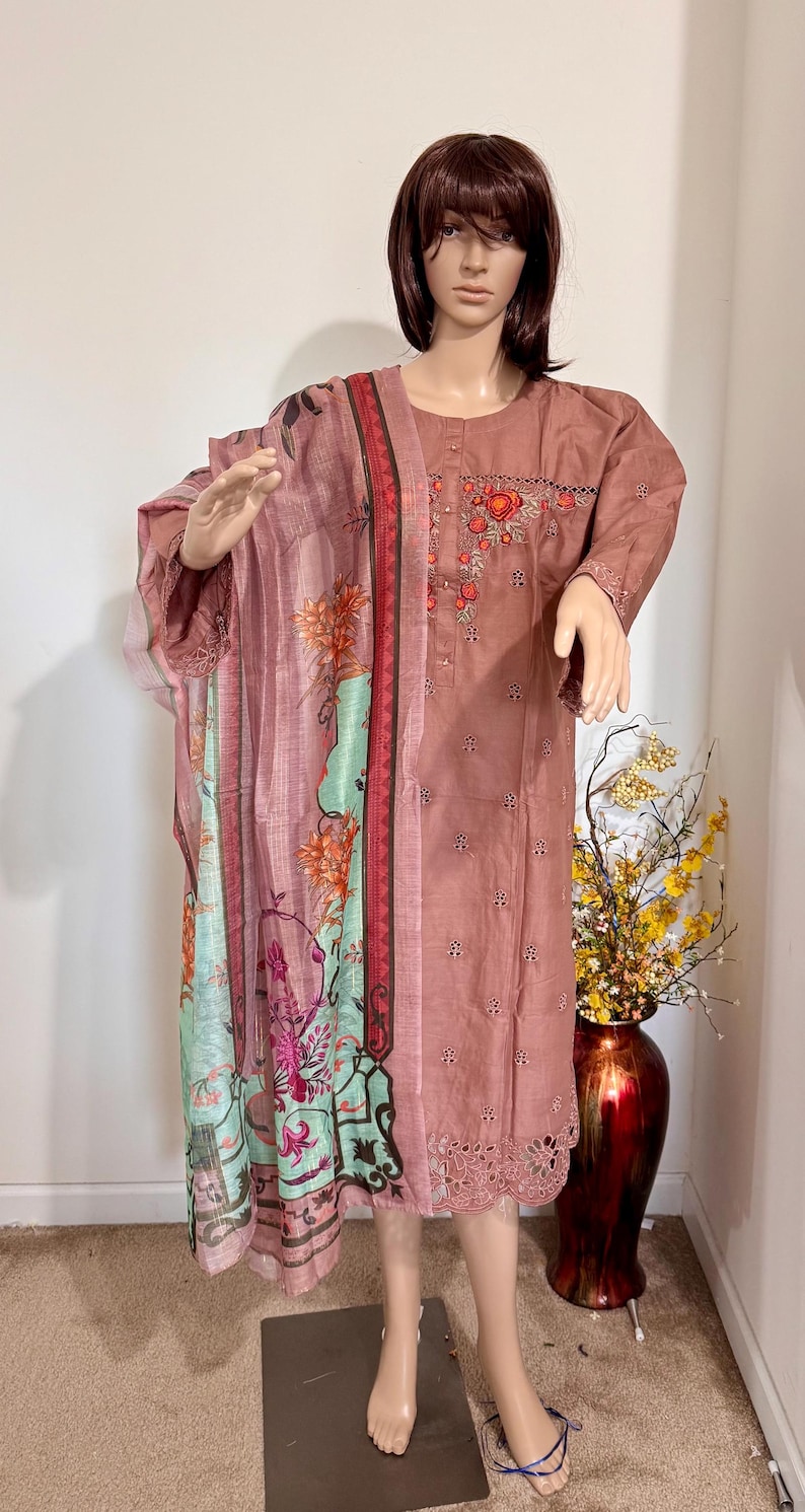 Op de afbeelding: Een roze en groene dupatta met een bloemenprint en een roze geborduurde kurta. De kurta heeft een ronde hals en 3/4 mouwen. De dupatta heeft een gegolfde rand.