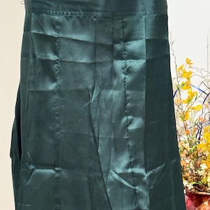 May include: A dark green satin skirt with pleats and a waistband.