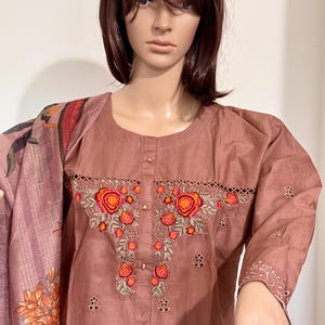 Op de afbeelding: Een mauve katoenen kurta met geborduurde bloemdetails in tinten oranje, rood en groen. De kurta heeft een ronde halslijn en driekwart mouwen.