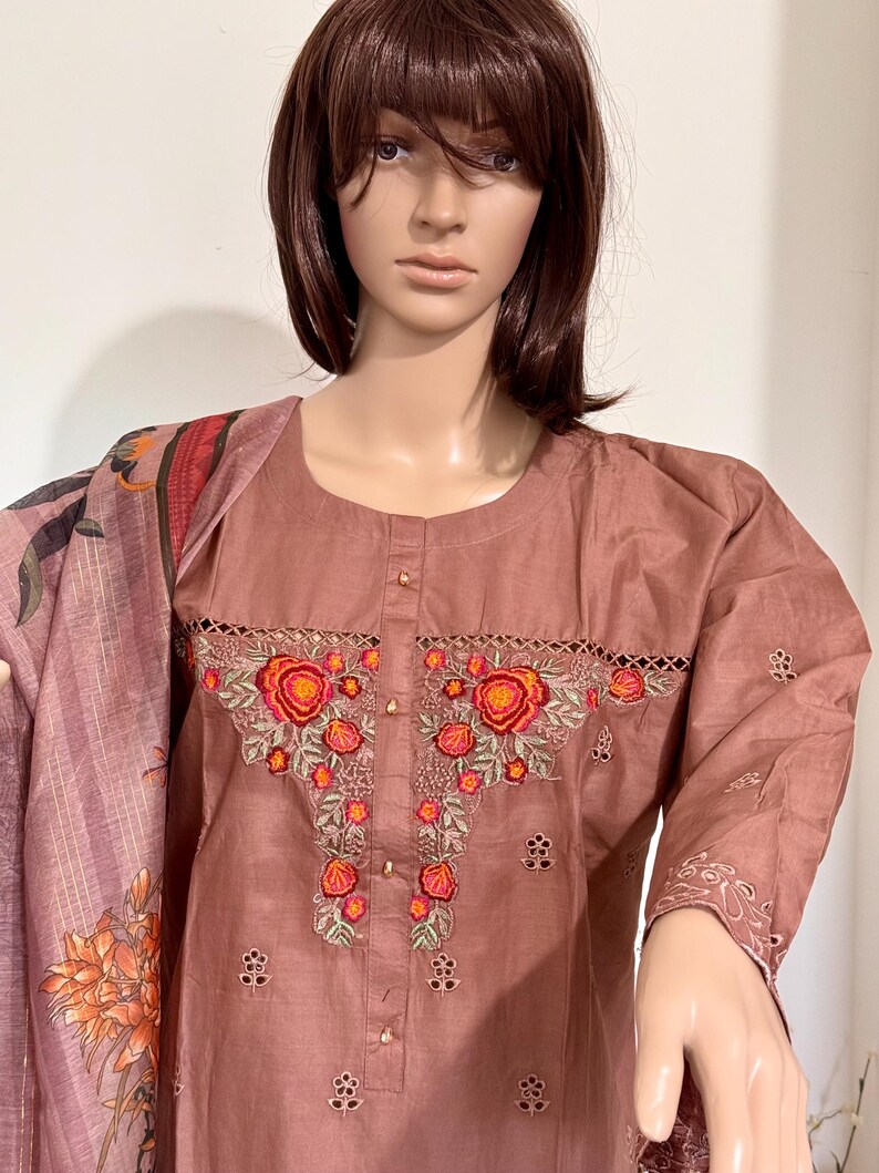 Op de afbeelding: Een mauve katoenen kurta met geborduurde bloemdetails in tinten oranje, rood en groen. De kurta heeft een ronde halslijn en driekwart mouwen.