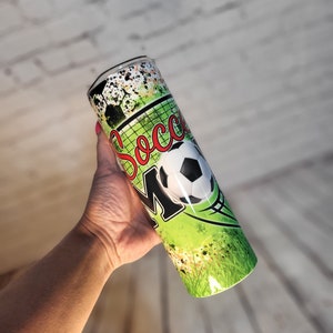 May include: Green and black stainless steel tumbler with a soccer ball and the word "Soccer Mom" printed on it.