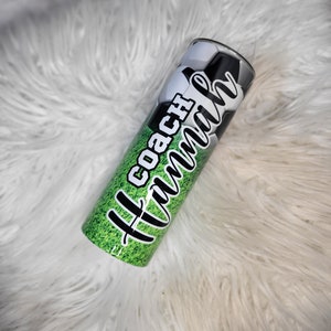 K&ouml;nnte beinhalten: Ein gr&uuml;ner und schwarzer Edelstahlbecher mit einem Fu&szlig;balldesign und dem Text "All Coach Mom".