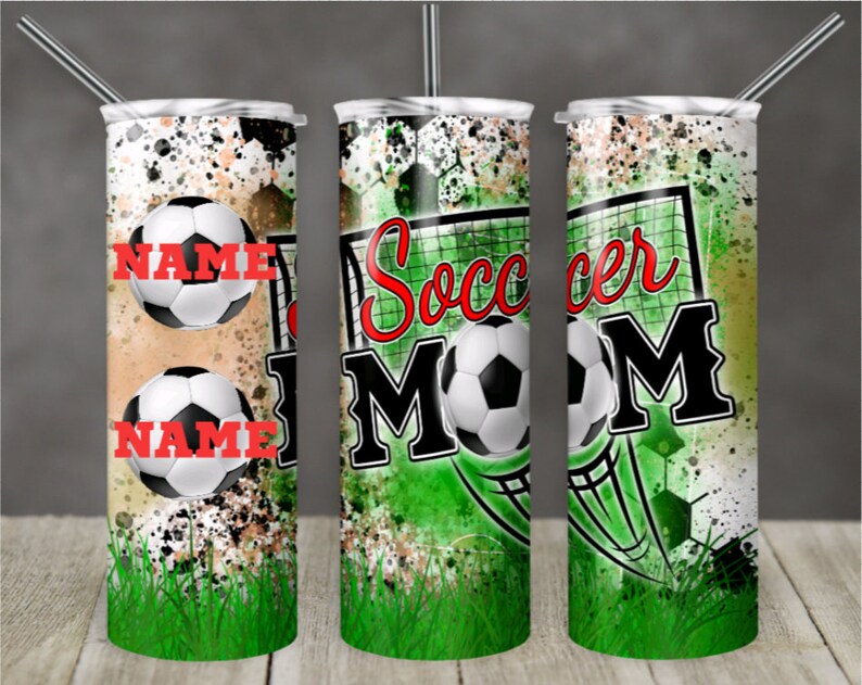 May include: A green, white, and black tumbler with a soccer ball and the words "Soccer Mom" on it. The tumbler has a splatter paint design and a green grass background.