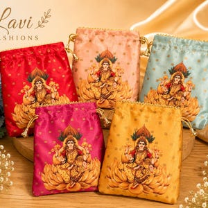 May include: Five rectangular drawstring pouches in red, peach, light blue, magenta, and gold satin fabric. Each pouch features a printed illustration of a deity seated on a lotus flower. The bags have gold-toned drawstring cords and beaded trim.