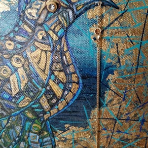 May include: An abstract painting of a bird in shades of blue, gold, and teal. The bird has a detailed mosaic-like pattern. A delicate gold chain with a charm hangs from the bird's beak. The background is a mix of gold and blue.