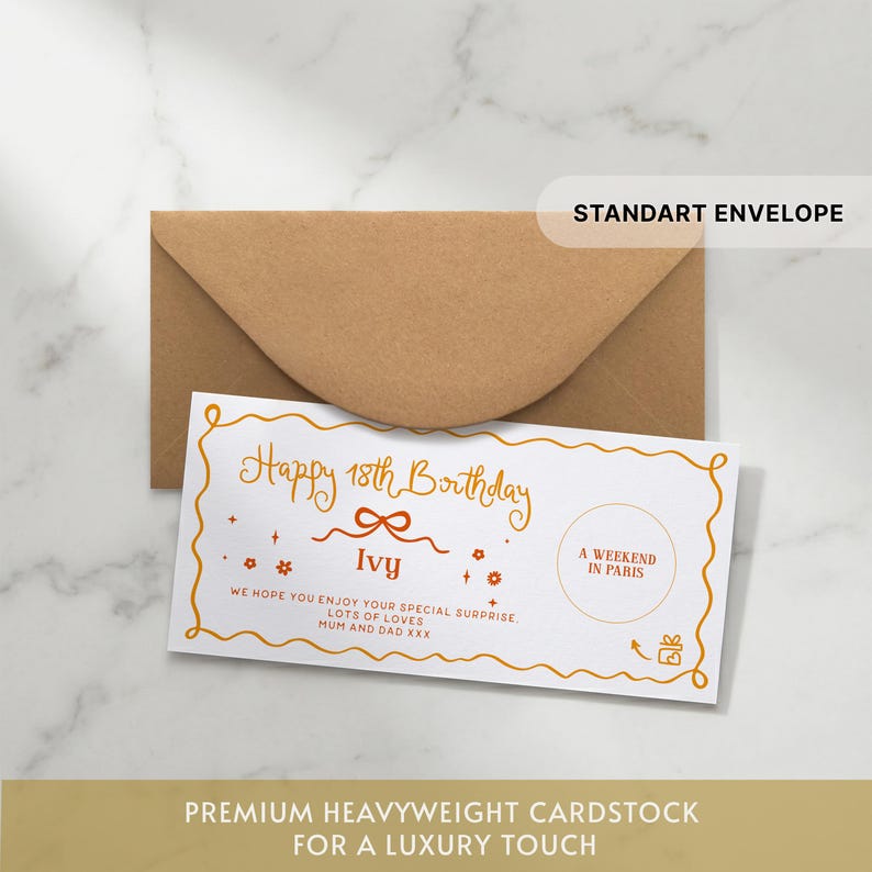 May include: A white rectangular gift voucher with a wavy orange border, featuring the text Happy 18th Birthday Ivy, A WEEKEND IN PARIS, and a message from Mum and Dad. The voucher is placed in front of a brown kraft paper envelope.