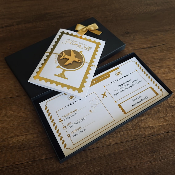 A scratch-card boarding pass in a luxury foil box — a genuinely theatrical way to announce a surprise holiday that turns the reveal into a moment.