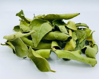 May include: A pile of dried kaffir lime leaves. The leaves are a vibrant green color and have a slightly curled shape.