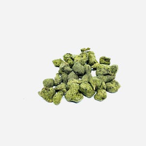 Könnte beinhalten: Nahaufnahme eines Haufens grüner Teeblätter, die zu kleinen Kugeln geformt sind.