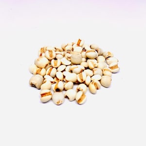 Puede incluir: Primer plano de un montón de cebada perlada, un tipo de grano, sobre un fondo blanco.