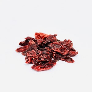 May include: A pile of dried goji berries on a white background. The berries are a deep red color and have a wrinkled texture.
