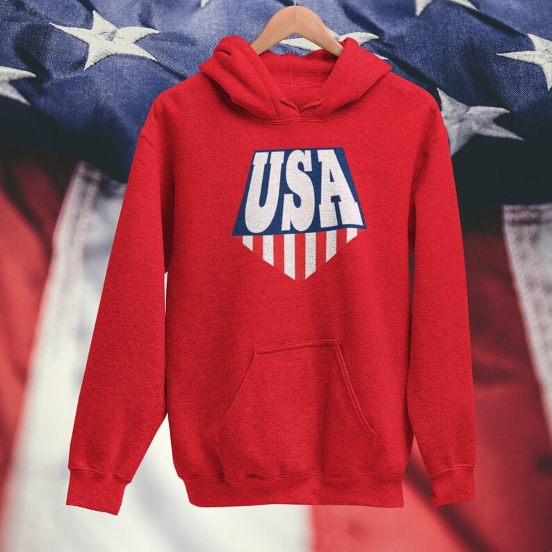 May include: Red hooded sweatshirt with a white and blue graphic of the word "USA" in a shield shape with stripes.
