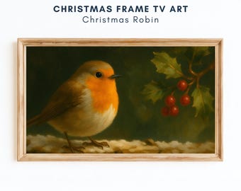May include: A framed digital art print titled "Christmas Robin." The artwork shows a robin with an orange breast and brown feathers on a snowy branch, with holly berries in the background. The frame is made of light-coloured wood.