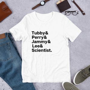 May include: White t-shirt with black text that reads "Tubby & Perry & Jammy & Lee & Scientist."