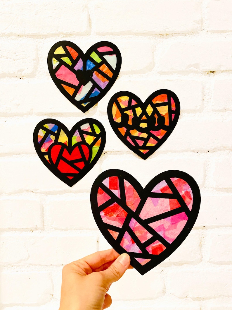 May include: Four heart-shaped decorations featuring black outlines and translucent, multi-colored segments. The hearts display various patterns of red, pink, yellow, orange, blue, and green colors, resembling stained glass art pieces.