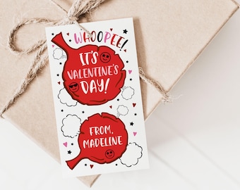 May include: A Valentine's Day gift tag with a red balloon design. The tag reads "WHOOPEE! IT'S VALENTINE'S DAY!" and "FROM, MADELINE" with cartoon smiley faces and star accents. The tag is tied to a wrapped gift.