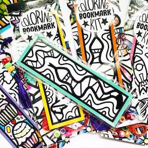 May include: A set of colorful coloring bookmark kits. Each kit includes a bookmark with a black and white design, beads, and string. The bookmarks feature different designs, including a rocket, a mermaid, and abstract patterns. The text "COLORING BOOKMARK KIT" is printed on one of the bookmarks.