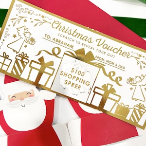 May include: A Christmas voucher with gold foil accents, featuring the text "Christmas Voucher" and "TO: ABRAHAM". The voucher has a scratch-off area revealing "$100 SHOPPING SPREE". Decorative elements include gift boxes and angels.