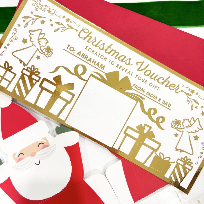 May include: A Christmas voucher with gold foil accents, featuring the text "Christmas Voucher" and "Scratch to Reveal Your Gift". The voucher is addressed "TO: ABRAHAM" and signed "FROM: MOM & DAD". A Santa Claus card is visible in the foreground.