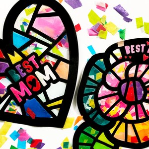 May include: Two colorful paper crafts, a heart and a flower, both with black outlines and filled with colorful tissue paper. The heart says "Best Mom" in pink letters with a small heart in the middle of the "O". The flower has a pink center and says "Best Mom" in pink letters with three small hearts above the text.