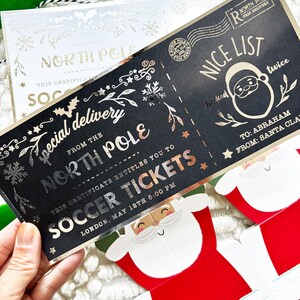 Pode incluir: Um bilhete de Natal preto e dourado com as palavras "Special Delivery From The North Pole" e "Soccer Tickets". O bilhete tem um gr&aacute;fico do Pai Natal e as palavras "Nice List" impressas.