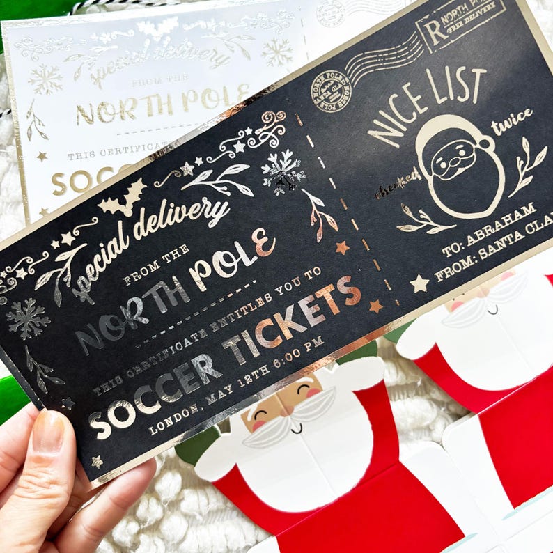 Pode incluir: Um bilhete de Natal preto e dourado com as palavras "Special Delivery From The North Pole" e "Soccer Tickets". O bilhete tem um gr&aacute;fico do Pai Natal e as palavras "Nice List" impressas.