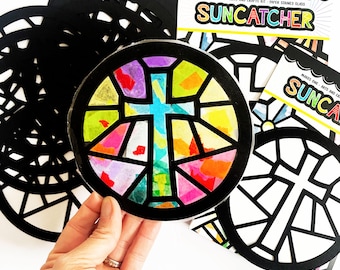May include: A stained glass suncatcher craft kit featuring a cross design. The kit includes multiple black paper stencils and one pre-coloured suncatcher with a cross design.
