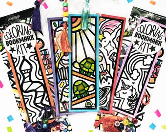 Könnte beinhalten: Vier Malvorlagen-Lesezeichen-Sets mit verschiedenen Designs. Jedes Set enthält ein Lesezeichen mit einer schwarzen und weißen Umrandung einer Schildkröte, eines Einhorns, einer Weltraumszene und einer Stadtlandschaft. Jedes Lesezeichen ist mit bunten Perlen und einem Quasten verpackt.