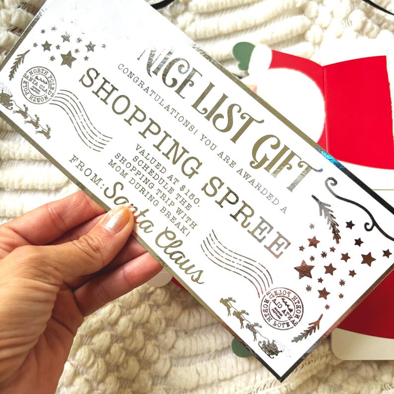 Pode incluir: Um vale-presente "Nice List Gift" para compras em prata e branco do Papai Noel. O certificado inclui texto e elementos decorativos como estrelas, renas e um selo do P&oacute;lo Norte. O certificado tem um valor de $150.