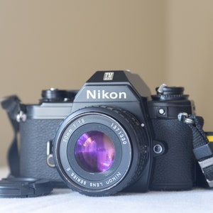 Nikon EM con Nikkor Series E 50 mm f1.8: cámara de película clásica de 35 mm con lente fija rápida, correa y medidor de funcionamiento