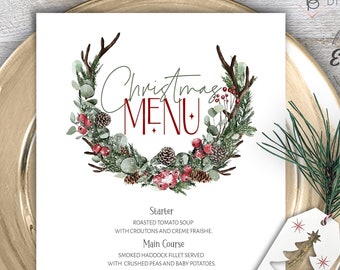 May include: A printable Christmas menu template featuring a watercolour wreath design with antlers, pine cones, berries, and greenery. The menu includes a starter, main course, and dessert.