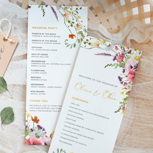 May include: Wedding ceremony programme with floral illustrations. The programme includes the wedding party, ceremony details, and a thank you message. The text is in gold lettering on a white background.