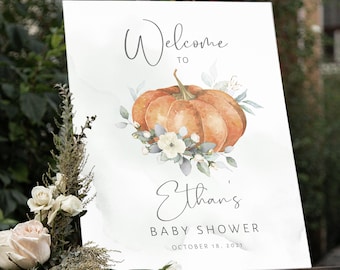 May include: Welcome to Ethan's Baby Shower sign with a watercolor pumpkin and floral design. The sign is on a wooden easel and says "Welcome to Ethan's Baby Shower" with the date "October 18, 2021".