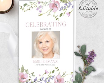 May include: A white memorial booklet with a floral design featuring pink and purple flowers. The booklet has the text "Celebrating the Life of Emilie Evans July 15, 1962 - March 11, 2022" and a photo of a woman.