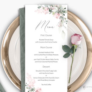 May include: A printable wedding menu template with a watercolor floral design in shades of pink and green. The menu features a three-course meal with options for each course: Roasted Tomato Soup, Smoked Haddock Fillet or pan Fried Chicken Breast, and Decadent Chocolate Fudge Cake or lemon Cheesecake.