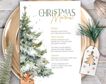 May include: A printable Christmas menu template featuring a watercolor illustration of a decorated Christmas tree with gold ornaments and a gift box. The menu includes a starter, main course, and dessert options.