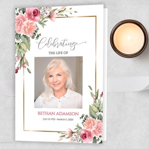 May include: A white memorial card with a gold frame and pink floral design. The text "Celebrating the Life of" is at the top of the card. A photo of a woman is in the center of the card. The text "Bethan Adamson" is below the photo, with the dates "July 15, 1932 - March 11, 2020".