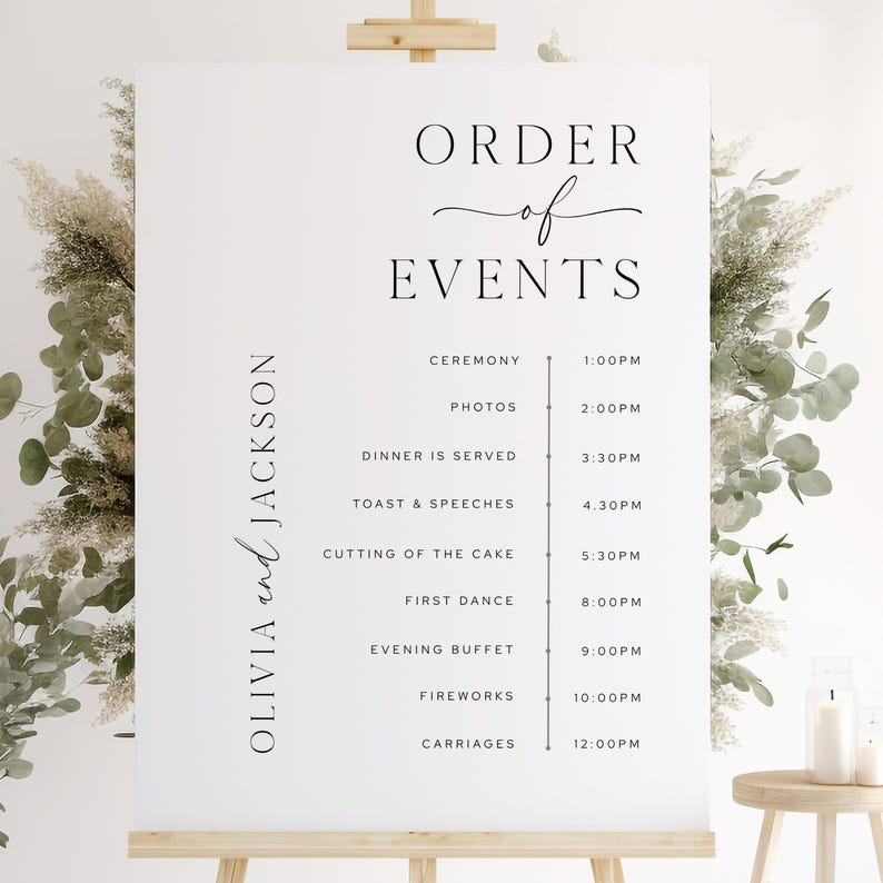 Op de afbeelding: Een wit trouwevenementbord op een houten ezel, met de tekst "ORDER of EVENTS" in elegant zwart schrift. Het bord geeft het schema weer, inclusief de ceremonie, het diner en het vuurwerk, met tijden. De namen "OLIVIA and JACKSON" worden ook weergegeven.