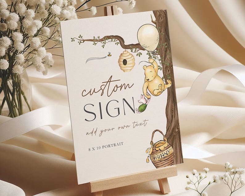 May include: A custom sign on a wooden easel, featuring a Winnie the Pooh illustration. The sign includes the text "custom SIGN" and "add your own text", with an 8 x 10 portrait format. The illustration shows Pooh Bear, Piglet, a beehive, and a honey pot.