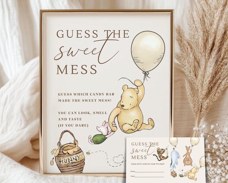 Peut inclure: Un panneau encadr&eacute; avec le texte "GUESS THE sweet MESS" et des illustrations de personnages de Winnie l'ourson. Le panneau comprend le texte "GUESS WHICH CANDY BAR MADE THE SWEET MESS!" et une petite carte avec le m&ecirc;me design.