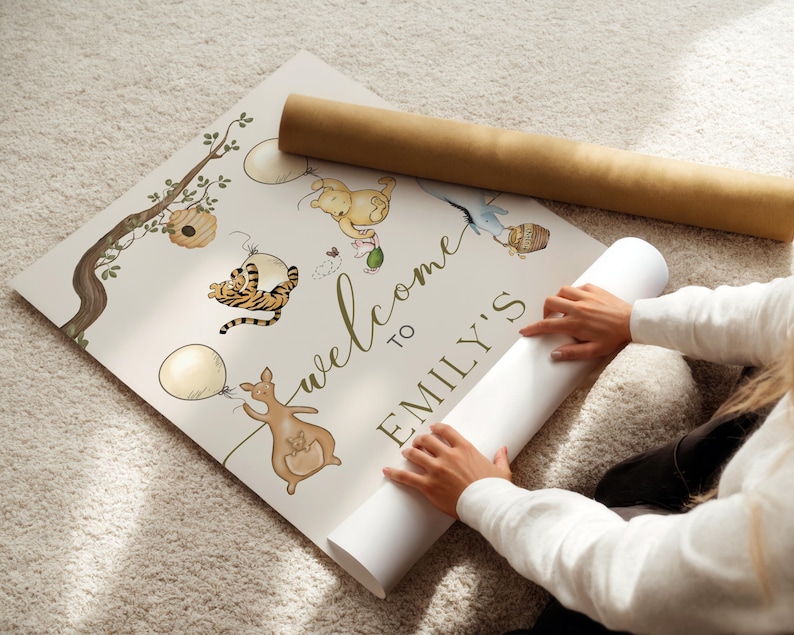 May include: A personalised welcome sign with the text "welcome to EMILY'S" in green script. The sign features watercolour illustrations of cartoon animals, balloons, and a tree branch. A rolled-up poster is next to the sign.